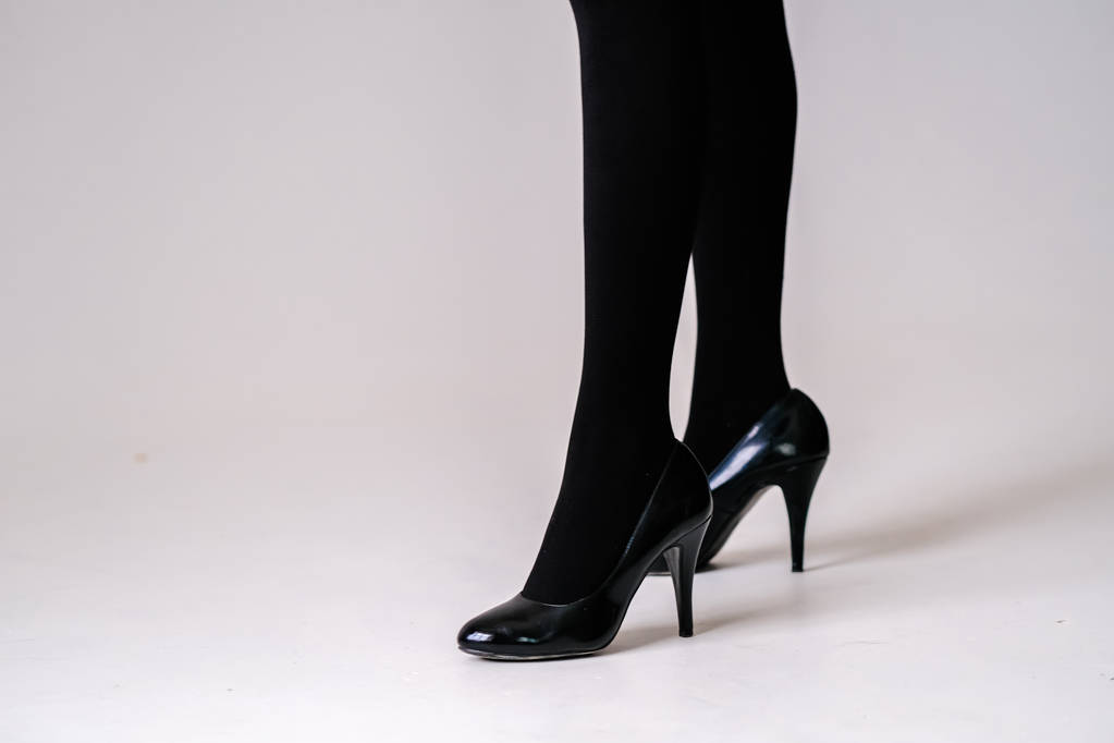 pies de mujer en medias negras o medias, zapatos negros de tacón alto
  - Foto, Imagen
