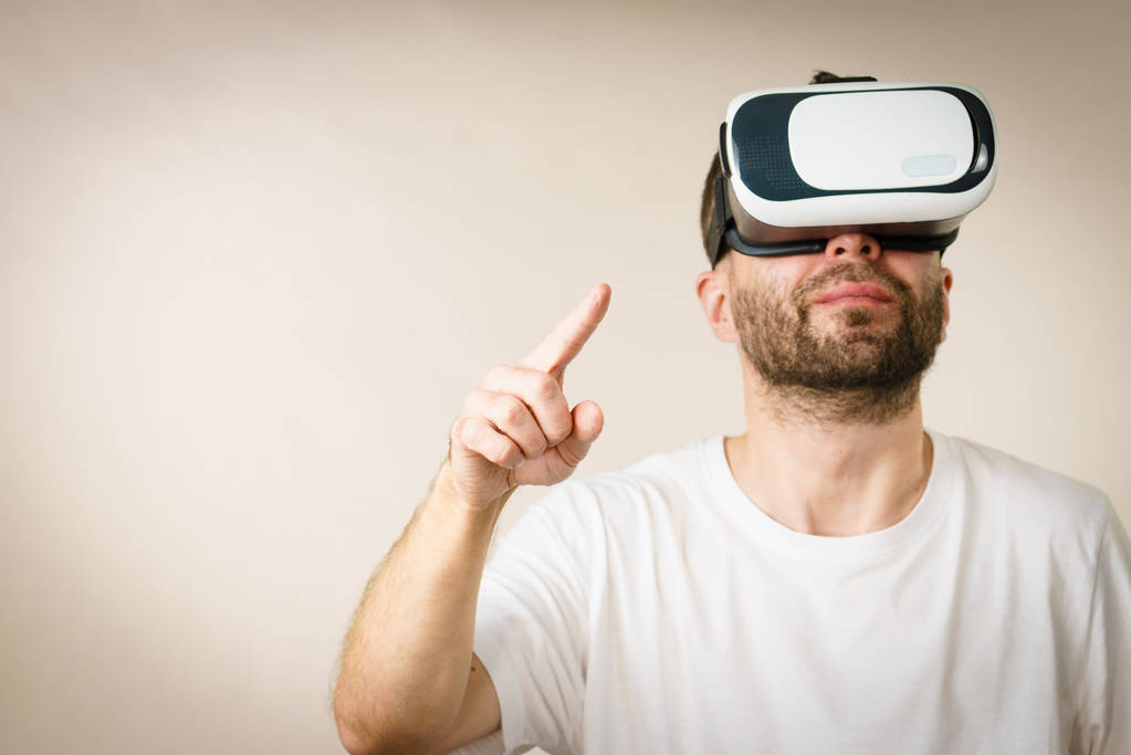 Adult short bearded guy exploring virtual reality wearing VR goggles being into technology. - Photo, Image