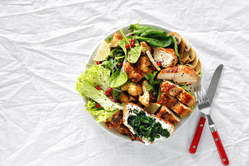 Ciotola con bistecca di pollo, cavolfiore fritto e insalata su sfondo bianco vista dall'alto. Concetto di cibo sano
 - Foto, immagini