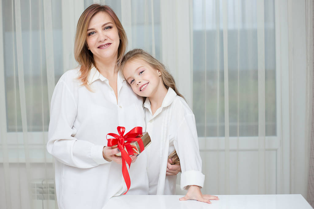 Dochter geven haar moeder een kerstcadeau thuis in de woonkamer - Foto, afbeelding