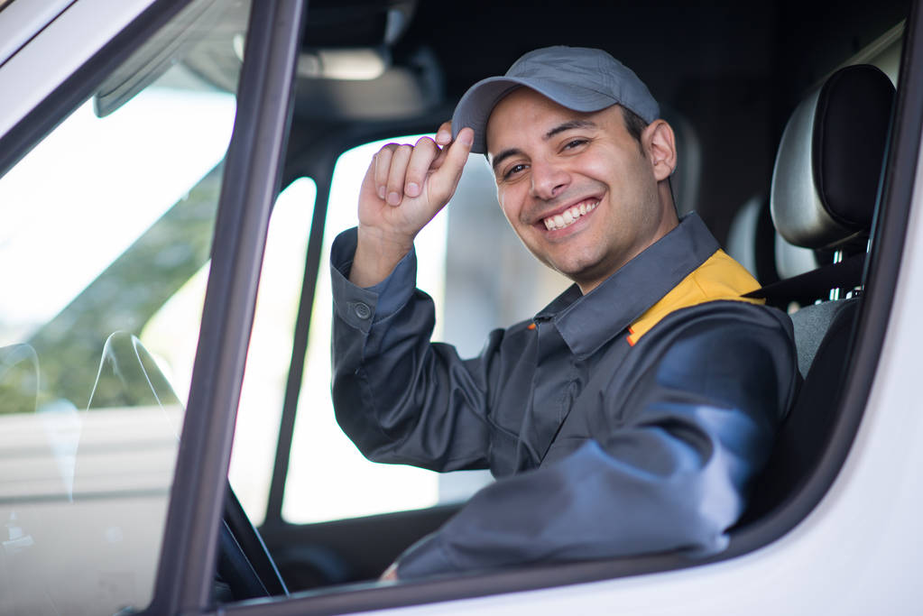 Усміхнений водій фургона тримає капелюх
  - Фото, зображення