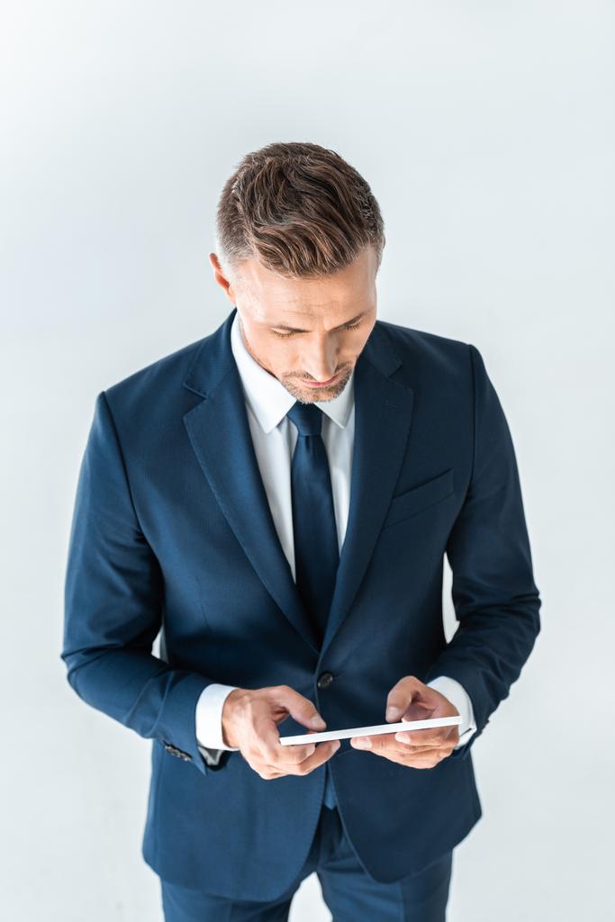 высокий угол зрения красивый бизнесмен с помощью планшета изолированы на белом
 - Фото, изображение