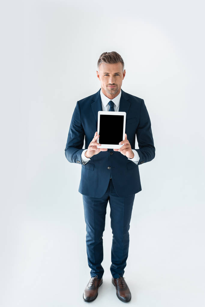 μεγάλη γωνία θέα όμορφος επιχειρηματίας δείχνει tablet με κενή οθόνη που απομονώνονται σε λευκό - Φωτογραφία, εικόνα