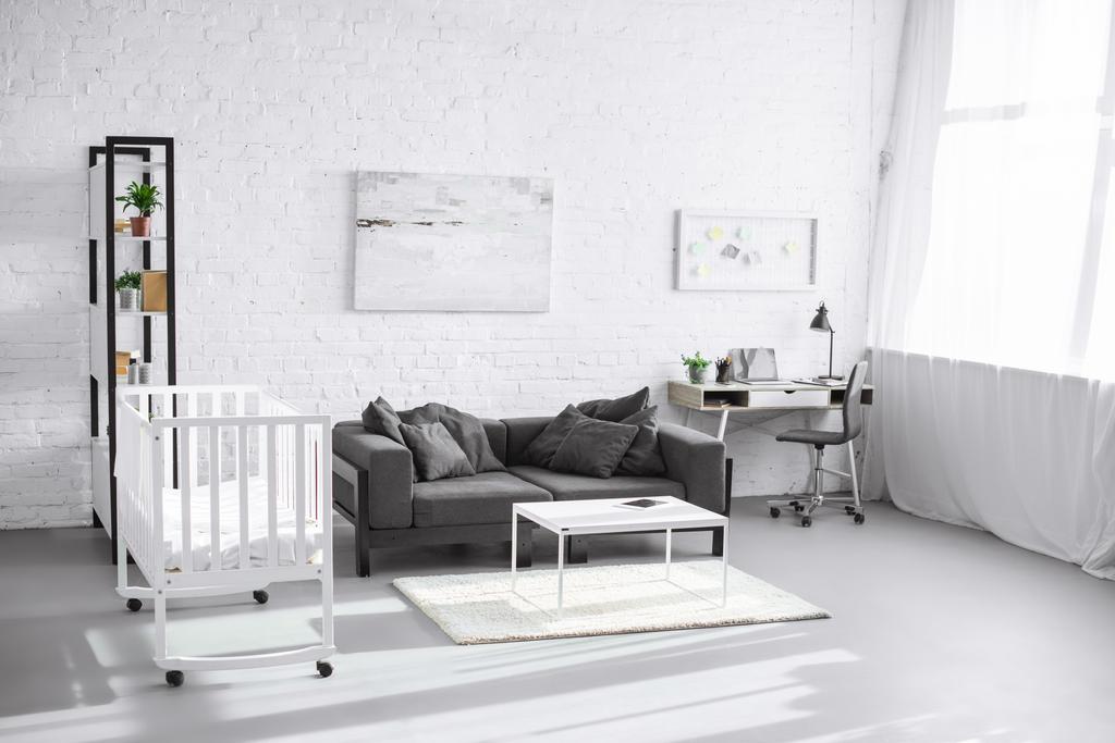 moderno interior de la sala de estar con cuna, sofá y lugar de trabajo
 - Foto, Imagen