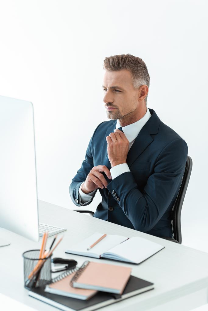 jóképű üzletember árukapcsolás nyakkendő asztalnál számítógép elszigetelt fehér - Fotó, kép