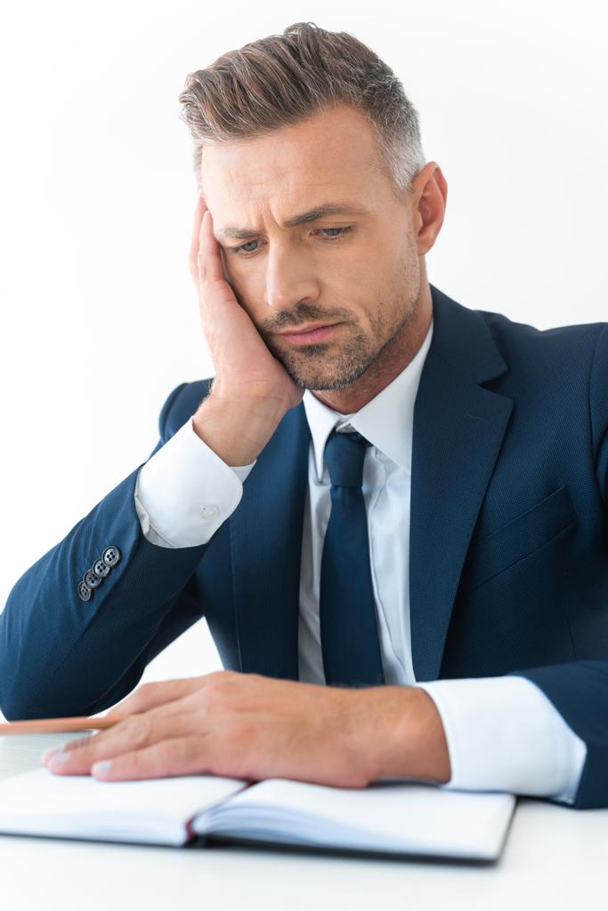 fáradt jóképű üzletember keresi elszigetelt fehér notebook - Fotó, kép