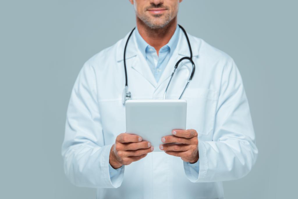 oříznutého obrazu lékař v bílém plášti drží tablet izolované na bílém - Fotografie, Obrázek