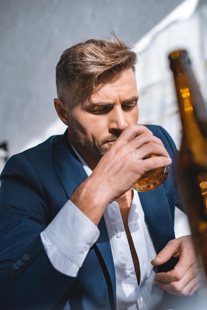 selectieve aandacht van zakenman houden van glas en het drinken van whisky  - Foto, afbeelding