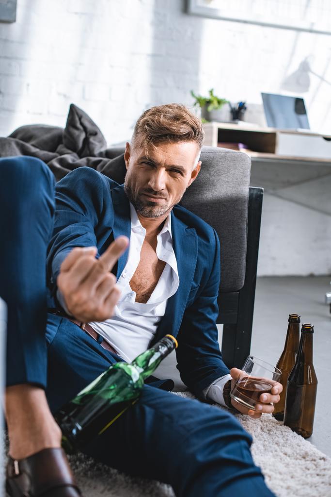 drunk businessman showing middle finger and holding glass with alcohol drink  - Photo, Image