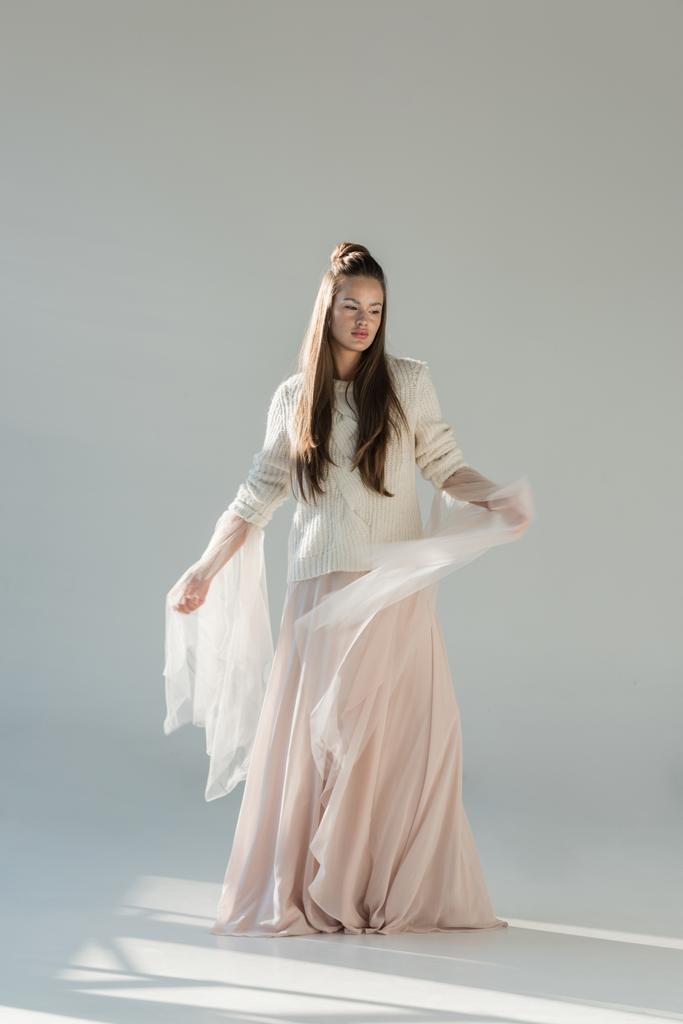 mulher atraente de pé em camisola de inverno elegante e saia em branco
 - Foto, Imagem