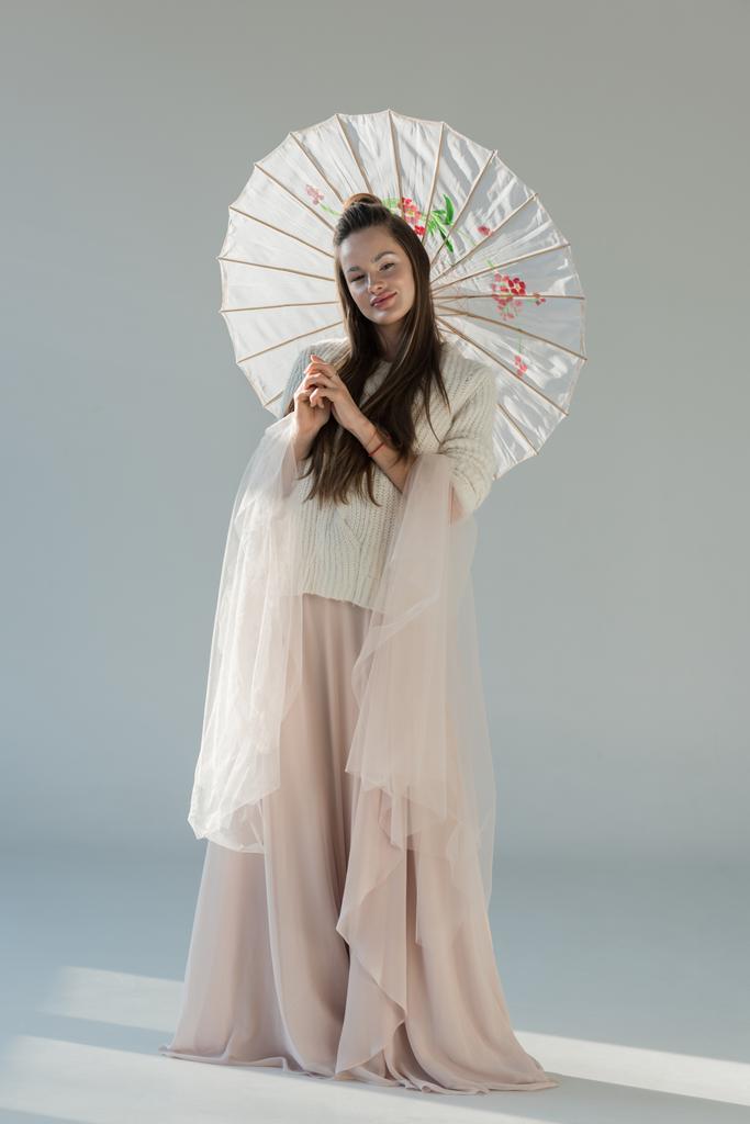menina bonita na roupa de inverno na moda em pé com guarda-chuva japonês no branco
 - Foto, Imagem