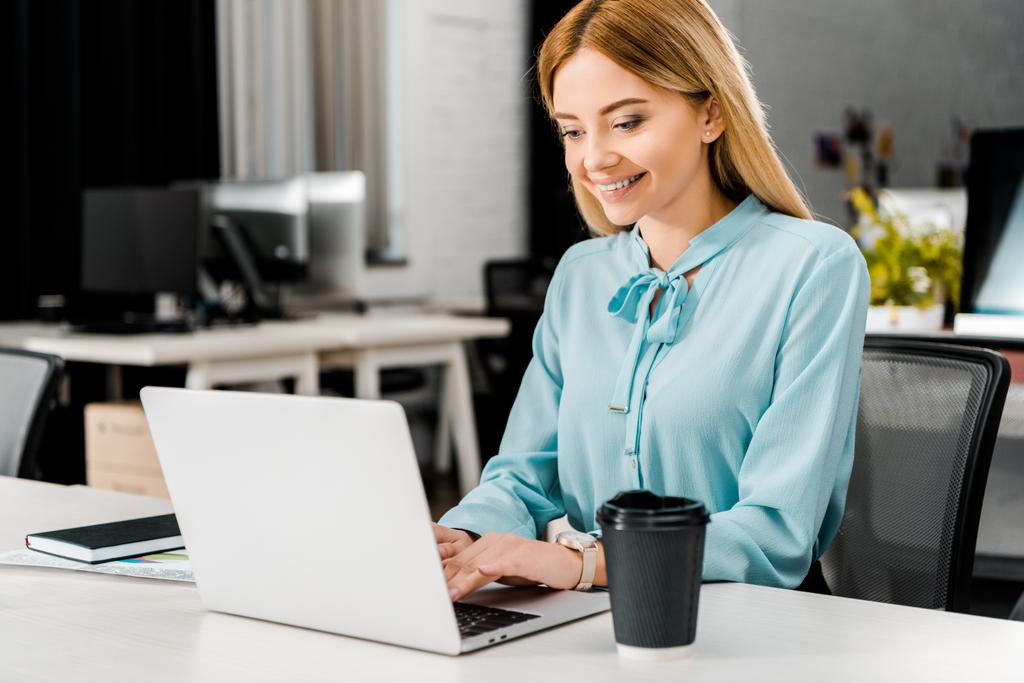 Portret uśmiechniętej bizneswoman pracującej na laptopie w biurze - Zdjęcie, obraz