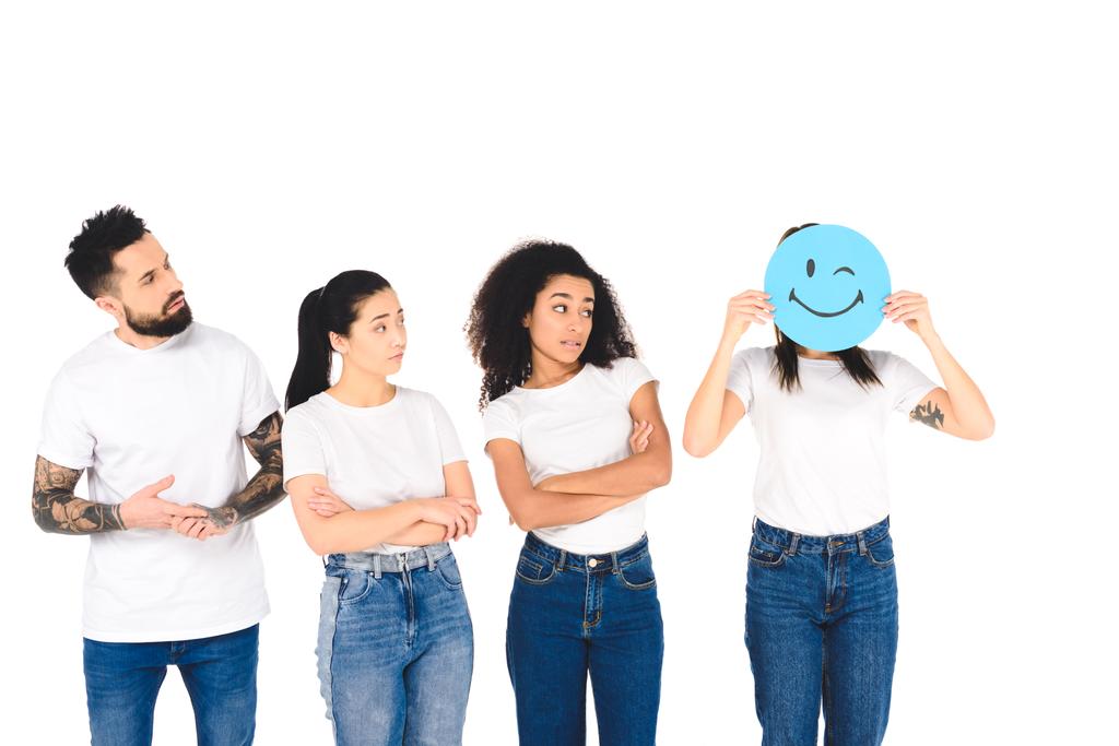 Multikulturelle Freunde schauen Mädchen mit zwinkerndem Schild isoliert auf Weiß an - Foto, Bild