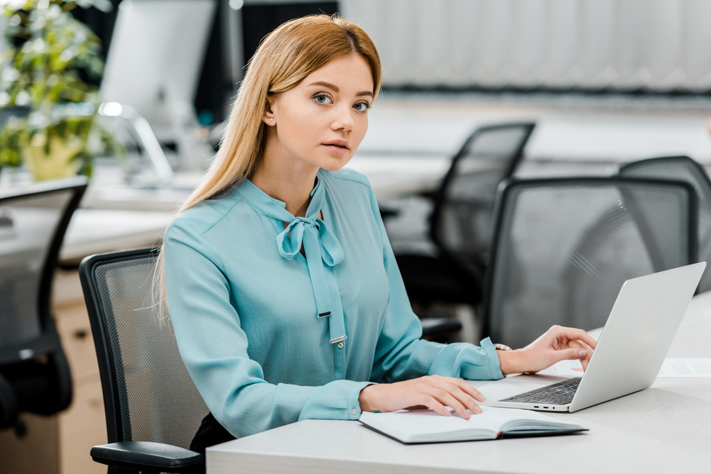 jonge zakenvrouw op werkplek met laptop en notitieboekjecomputer in kantoor - Foto, afbeelding