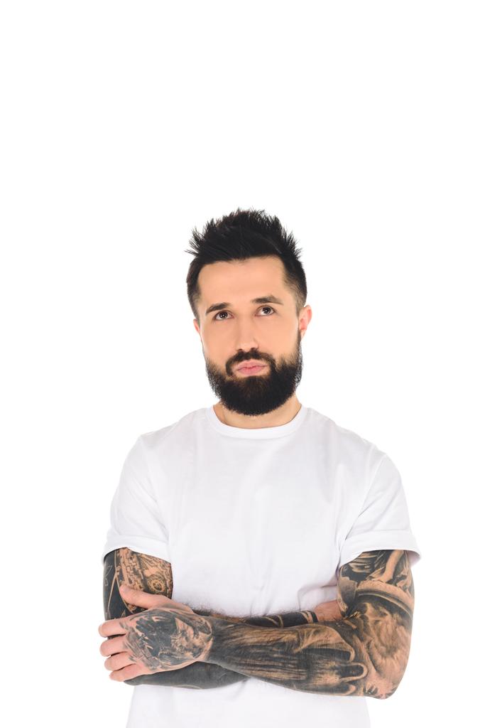 hombre barbudo en camiseta blanca con tatuajes mirando hacia arriba aislado en blanco
 - Foto, Imagen