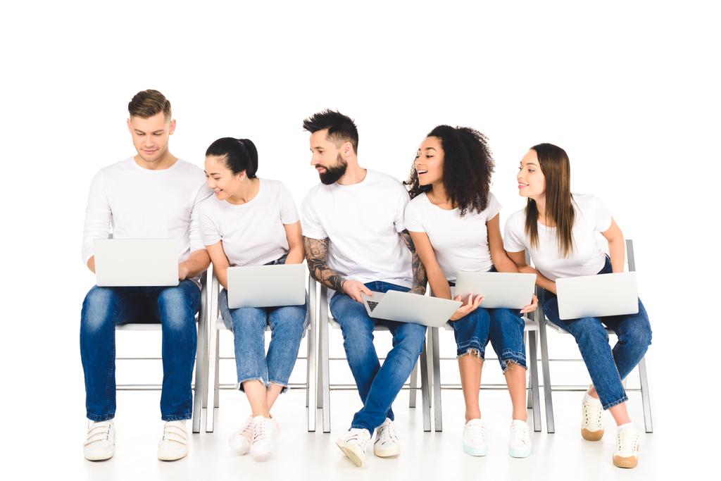 мультикультурная любопытная группа молодых людей, глядя на ноутбук изолирован на белом
 - Фото, изображение