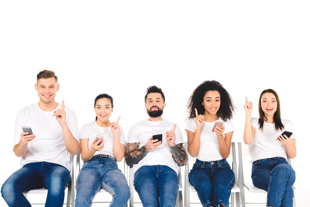 groupe multiculturel de jeunes utilisant des smartphones et montrant des signes d'idée isolés sur blanc
 - Photo, image