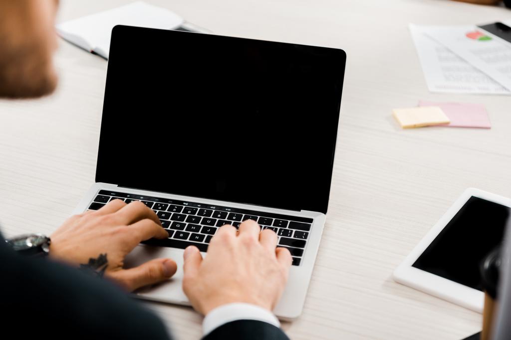 visão parcial do empresário digitando no laptop com tela em branco no escritório
 - Foto, Imagem