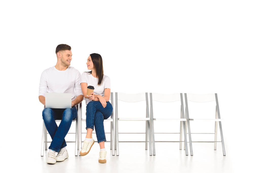 menina atraente sentado com café para ir e flertando com homem bonito isolado no branco
 - Foto, Imagem