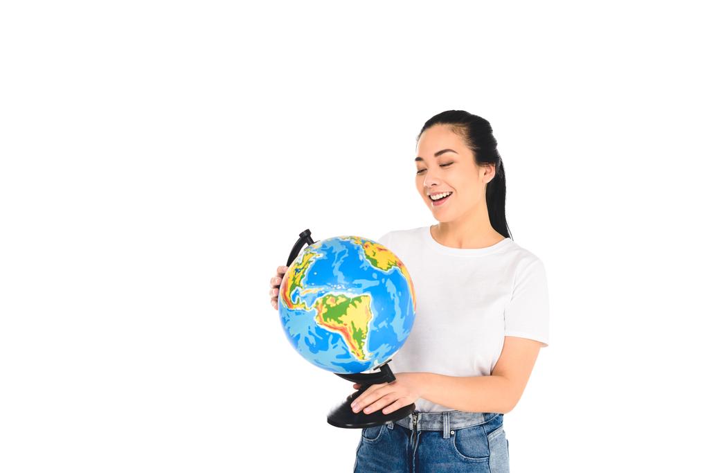 Lächelnde junge Frau blickt auf Globus isoliert auf weißem Grund - Foto, Bild