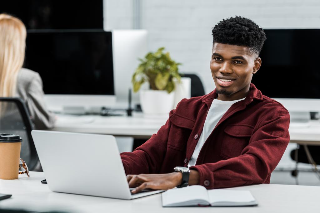 jeune homme d'affaires afro-américain sur le lieu de travail avec ordinateur portable au bureau
 - Photo, image