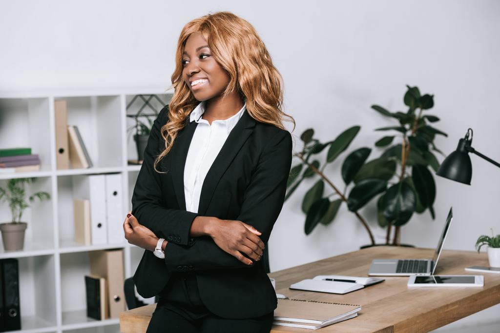 mujer de negocios afroamericana con brazos cruzados en oficina moderna
  - Foto, Imagen