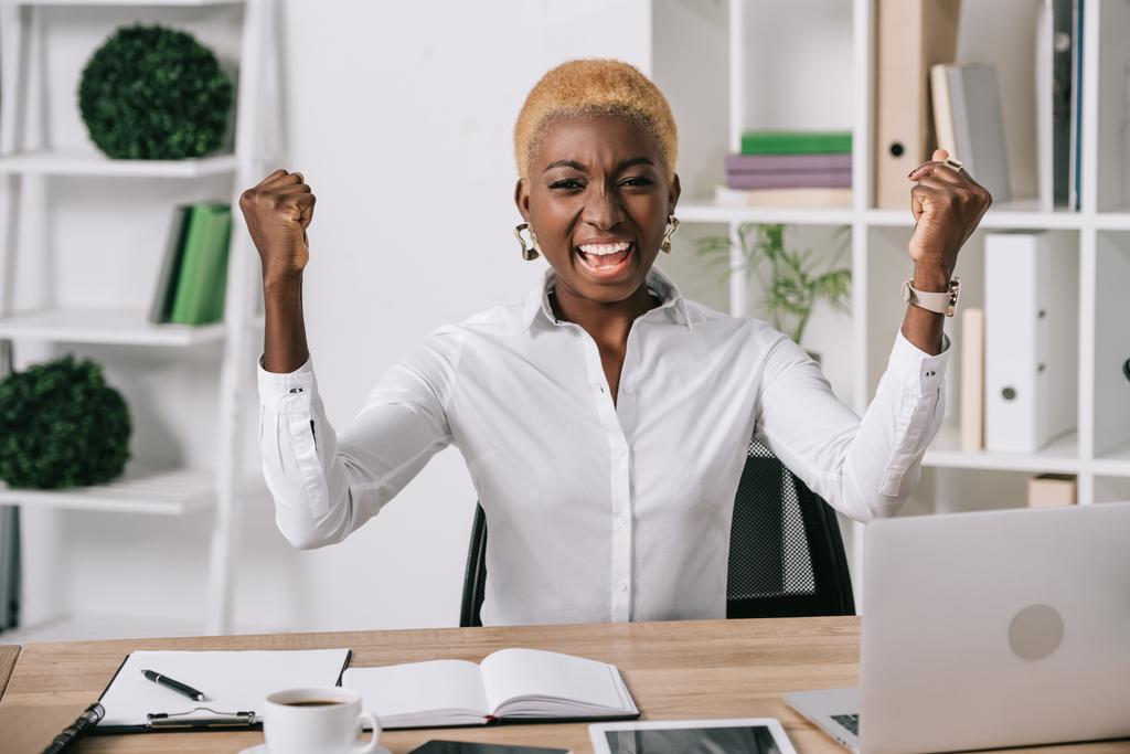 feliz mulher de negócios afro-americana sorrindo e mostrando sinal de vitória
 - Foto, Imagem