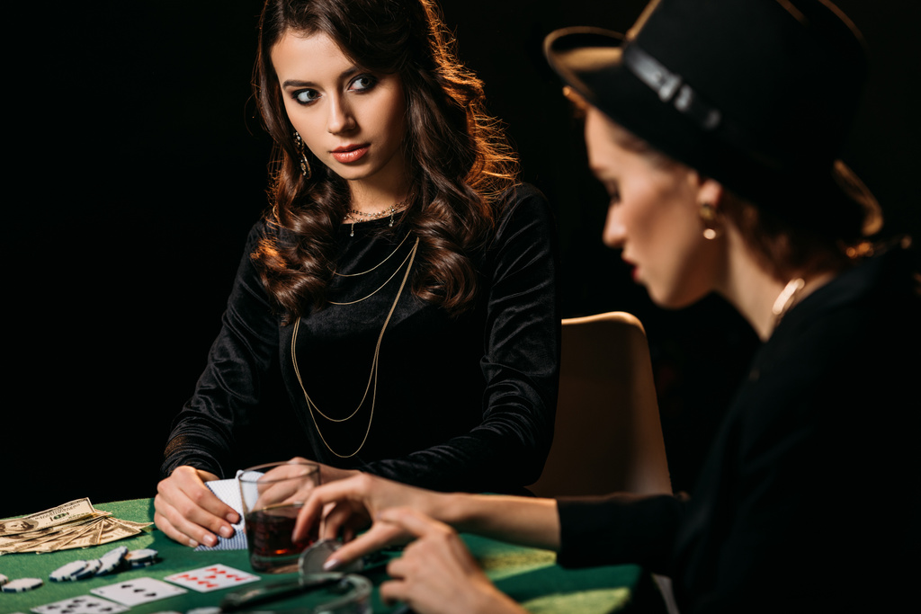 ragazze attraenti che giocano a poker a tavolo in camera oscura nel casinò
 - Foto, immagini