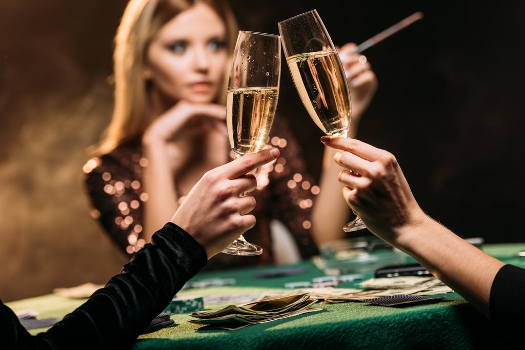foco seletivo de meninas atraentes clinking com copos de champanhe na mesa de poker no cassino
 - Foto, Imagem