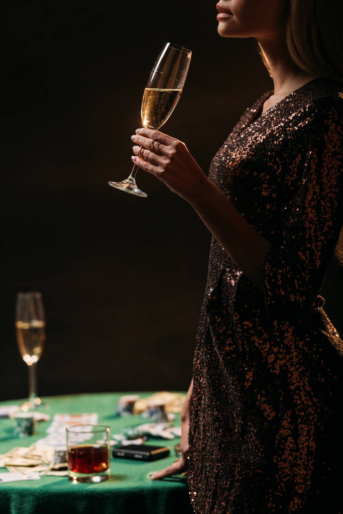 bijgesneden afbeelding van meisje champagne drinken bij casino - Foto, afbeelding