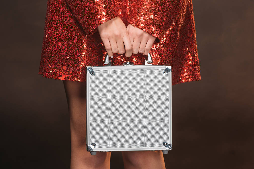 imagem cortada de menina em vermelho vestido brilhante segurando caixa de dinheiro isolado no preto
 - Foto, Imagem