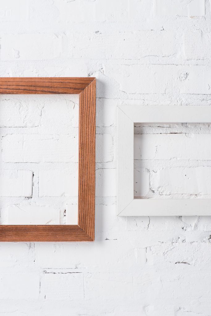 marcos vacíos marrones y blancos colgando en la pared de ladrillo
 - Foto, Imagen