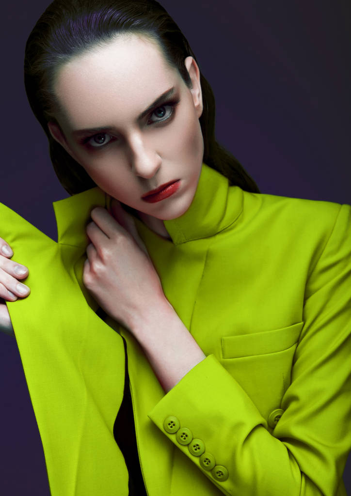 Модна модель з мокрим волоссям у зеленому довгому пальто на зеленому фоні. портрет моди
. - Фото, зображення