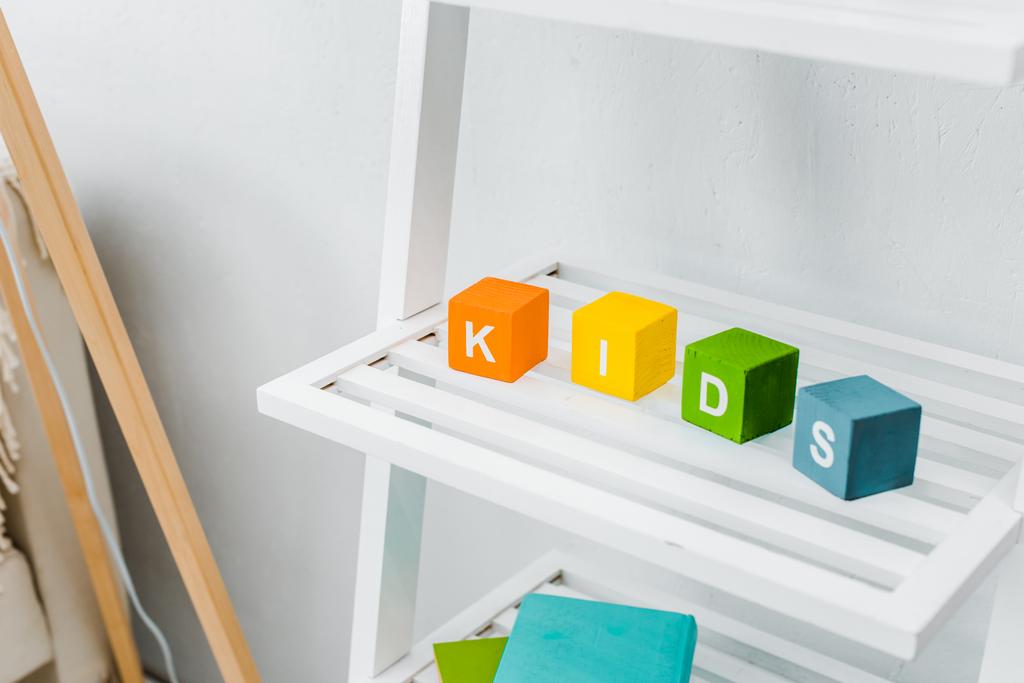 vista de cerca de cubos multicolores con letras de niños en el estante
  - Foto, imagen
