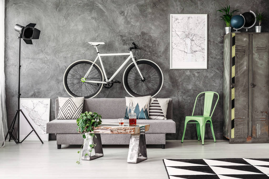 Σκούρο βιομηχανική σαλόνι με γκρι καναπές και λευκό ποδήλατο - Φωτογραφία, εικόνα