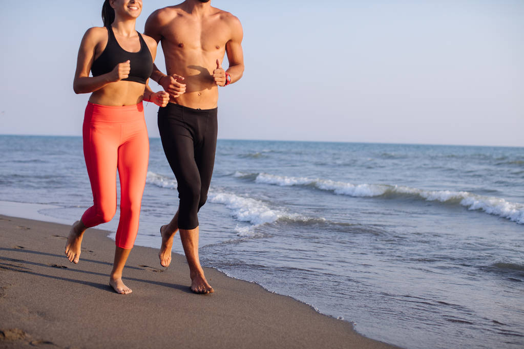 bel homme caucasien et belle femme courir sur la plage de sable
. - Photo, image