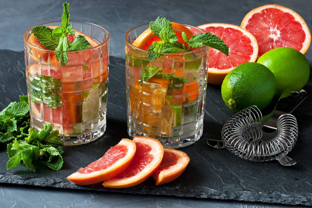Bebida fresca de cítricos con hojas de naranja, lima, pomelo y menta verde, enfoque selectivo - Foto, imagen
