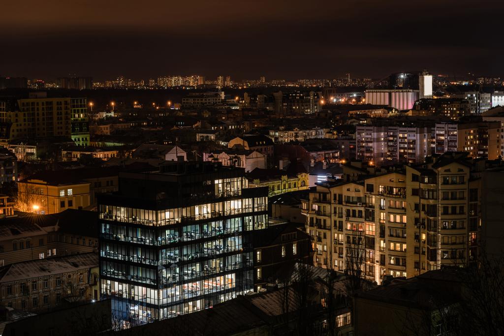 pimeän yön kaupunkikuva valaistuilla rakennuksilla
 - Valokuva, kuva