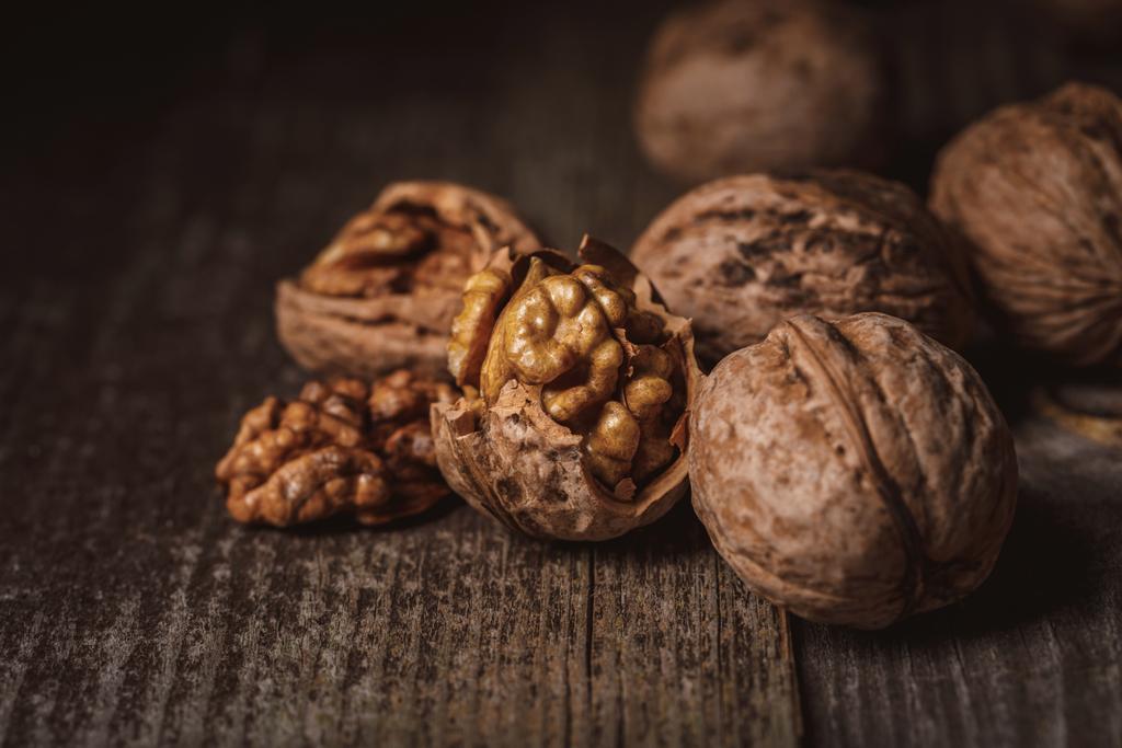 close up view of shelled and whole walnuts on wooden tabletop - Photo, Image