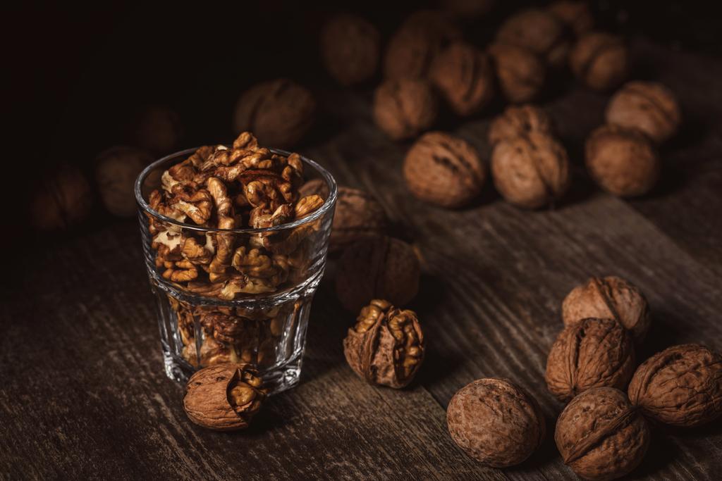 close up view of tasty shelled walnuts in glass on wooden table - Photo, Image
