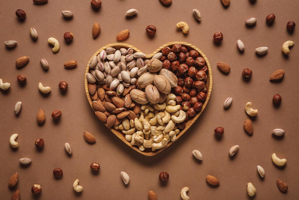 tasainen makasi sydämen muotoinen laatikko eri pähkinät valikoima ruskea pöytälevy
 - Valokuva, kuva