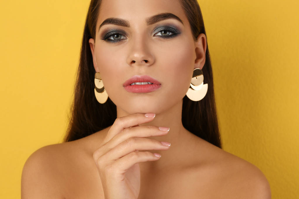 Retrato de mujer hermosa con maquillaje elegante sobre fondo de color
 - Foto, imagen