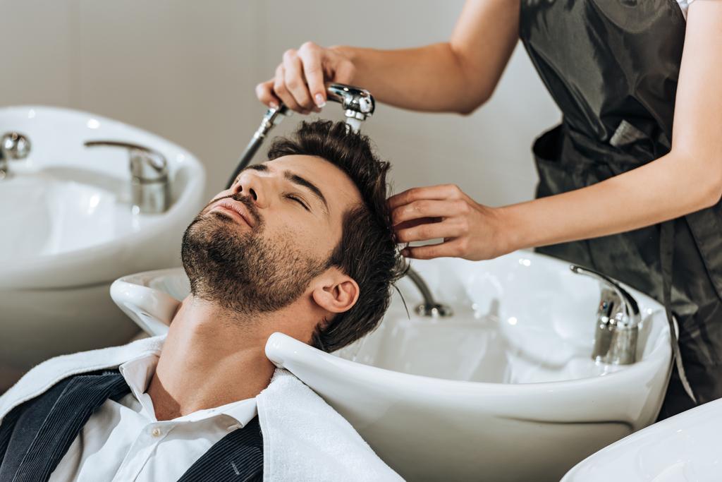 przycięty Zrzut z profesjonalnym fryzjerem mycia włosów męskich klienta w salonie piękności - Zdjęcie, obraz