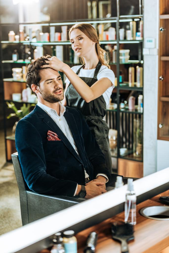 молода жінка-перукар робить зачіску красивому чоловікові в салоні краси
 - Фото, зображення