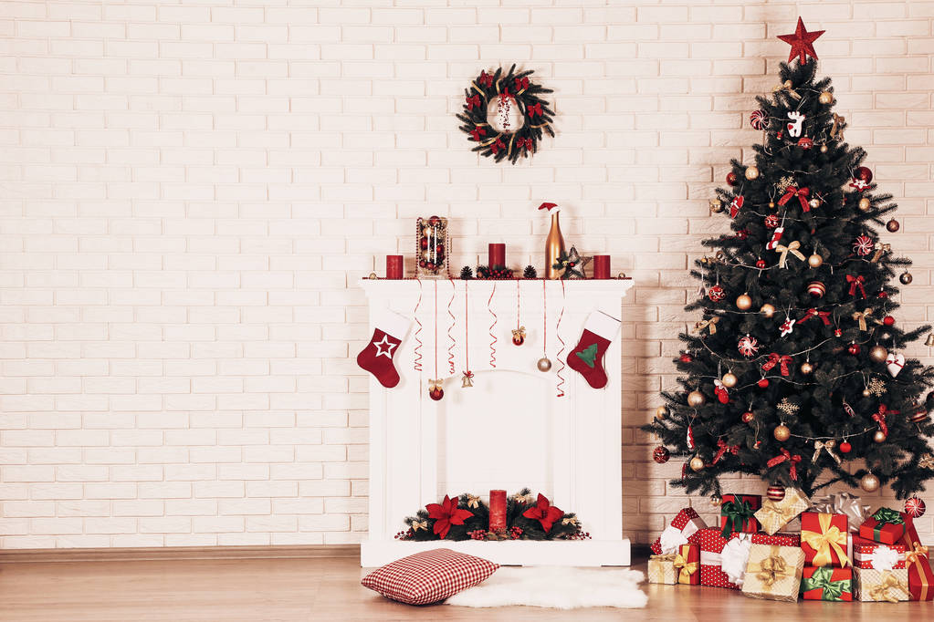 weiß dekorierter Kamin mit Weihnachtsbaum auf Backsteinmauer Hintergrund - Foto, Bild
