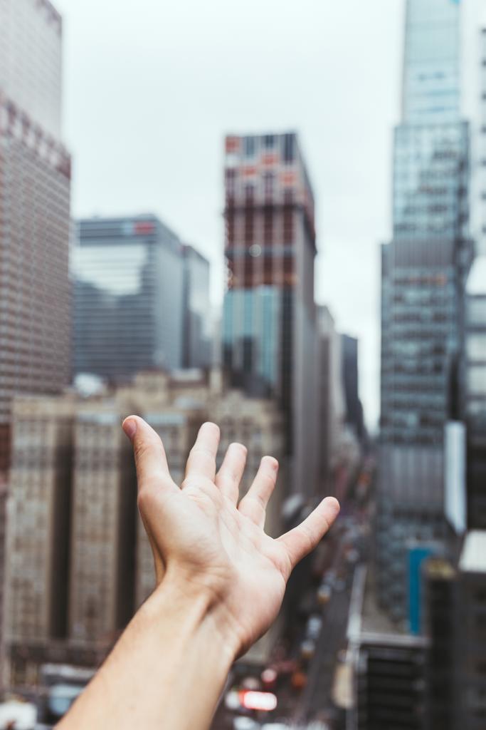 részleges kilátás a férfi kezét, és homályos new york city view háttér - Fotó, kép