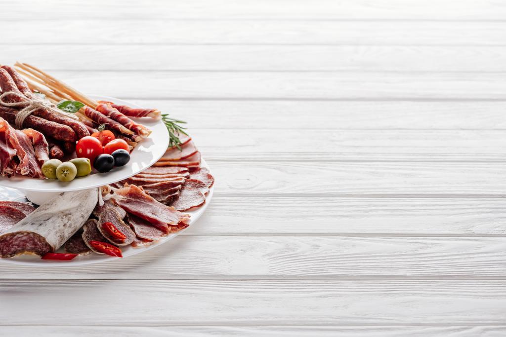 close up view of delicious meat appetizers with olives on white wooden tabletop - Photo, Image