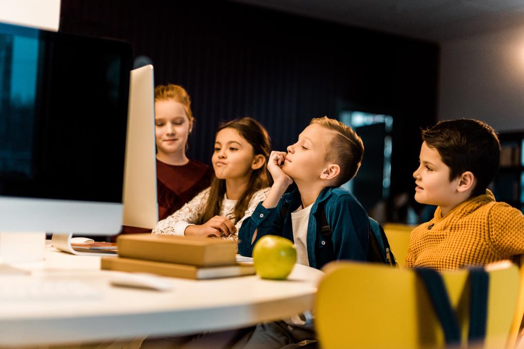 entzückende Schüler mit Desktop-Computer in moderner Bibliothek   - Foto, Bild
