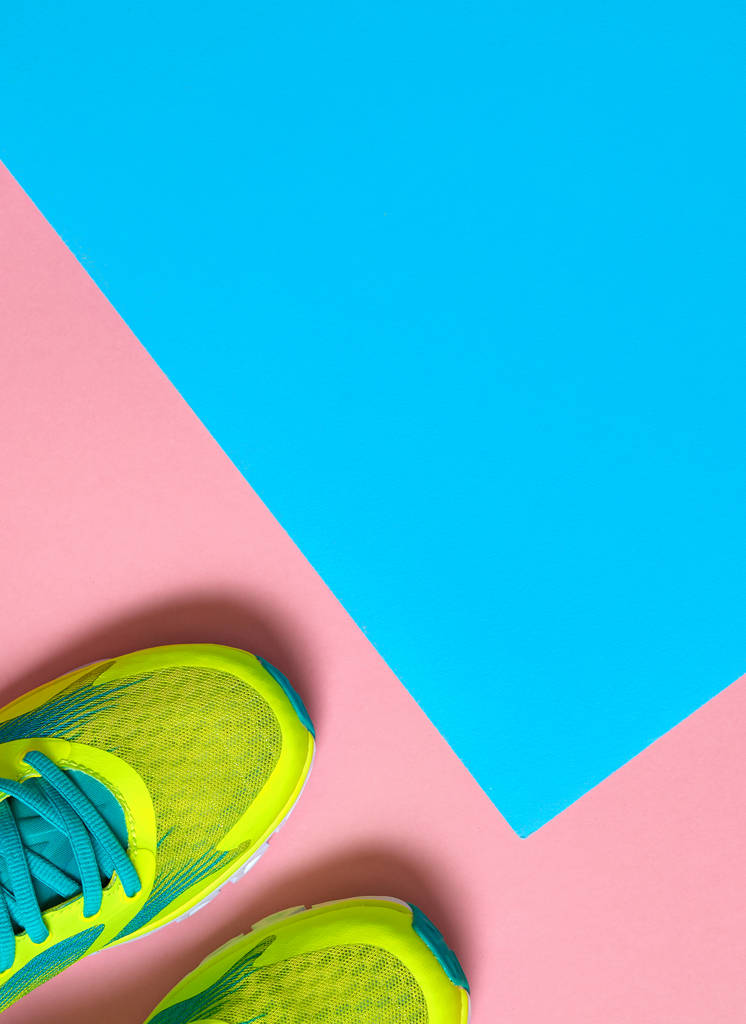 Pair of sport shoes on colorful background. New sneakers on pink and blue pastel background, copy space. Overhead shot of running shoes. Top view, flat lay - Photo, Image