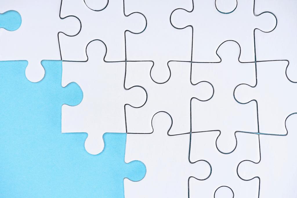 flache Lage mit weißen Puzzleteilen auf blauem Hintergrund - Foto, Bild
